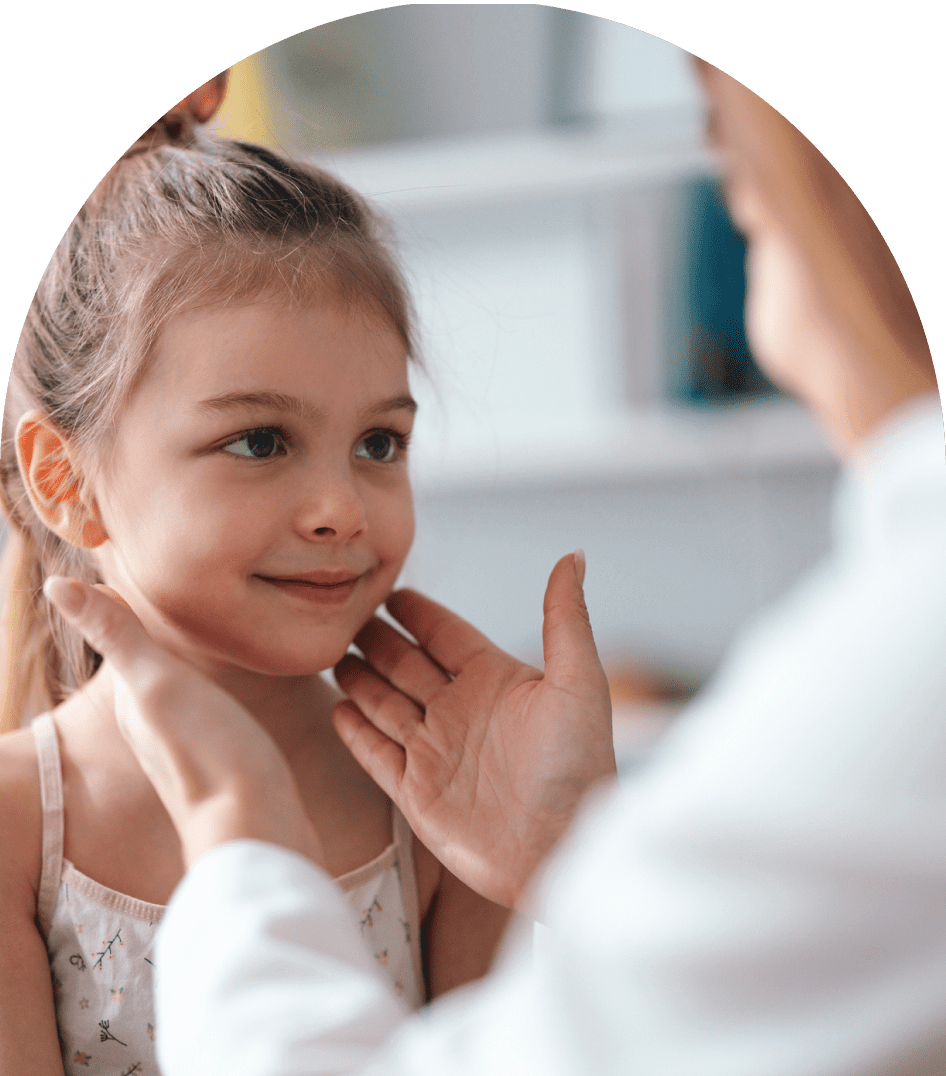 A girl smiling while an adult adjusts her collar.