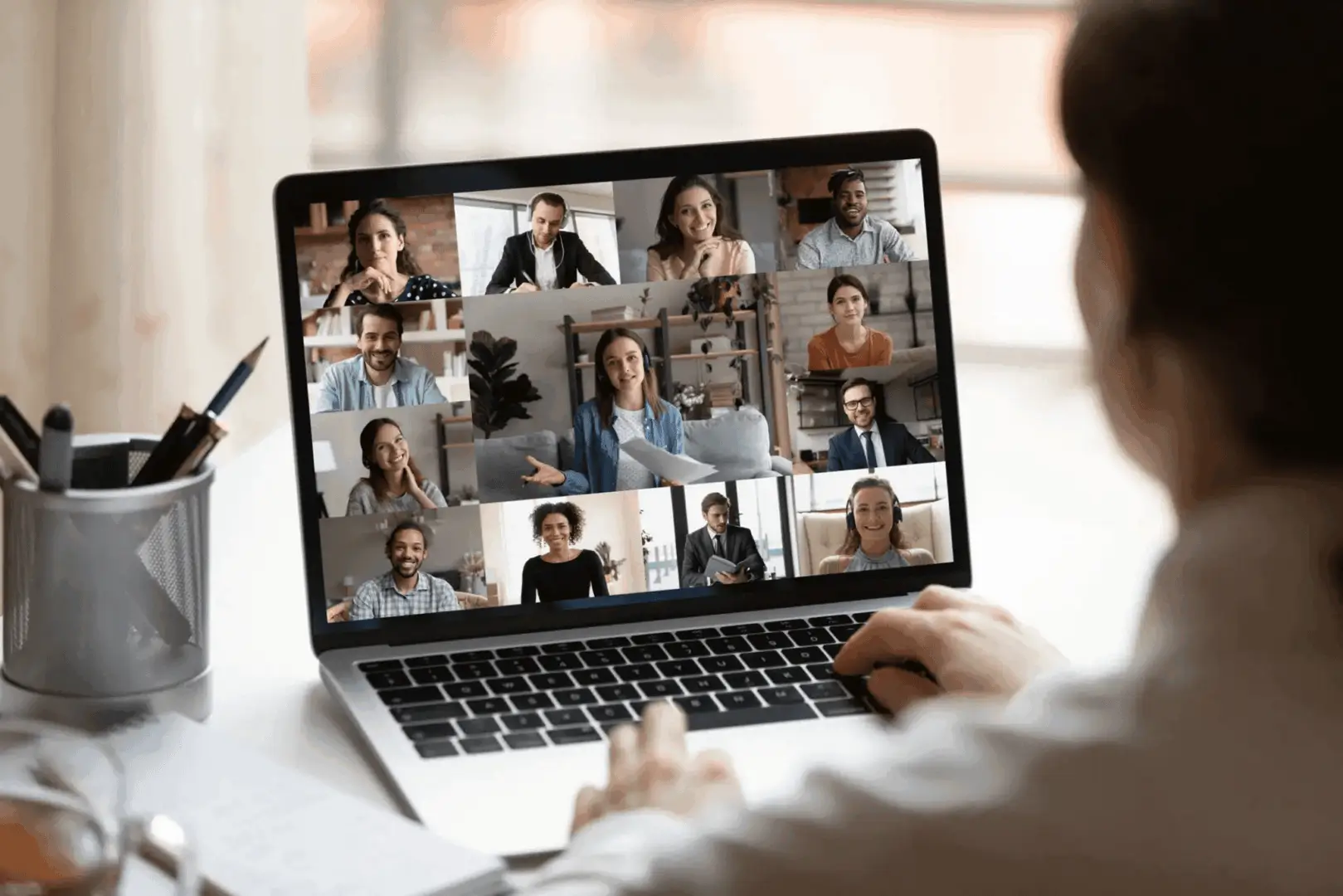 Person attending a virtual meeting on a laptop with multiple participants.